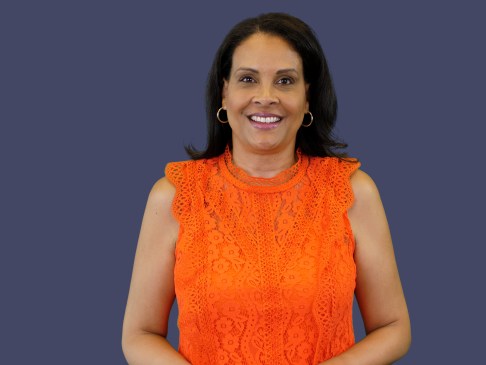 Woman in orange top against blue background