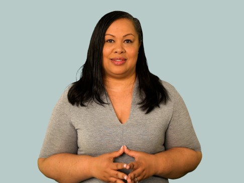 Woman in gray stop standing against gray background