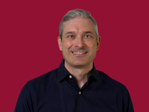man in black shirt against a crimson background