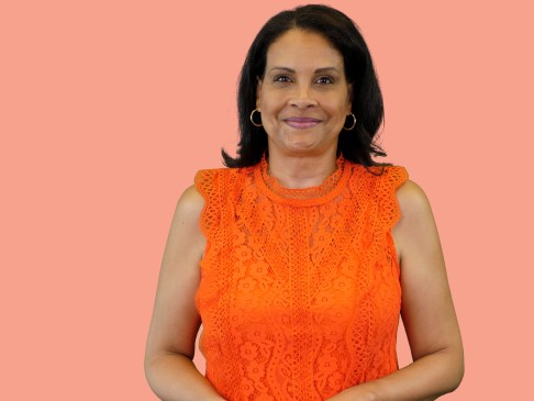 Woman in orange top against peach background