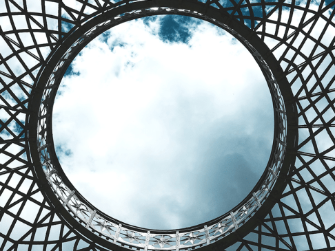Metal lattice framework with an opening in the middle showing a blue sky